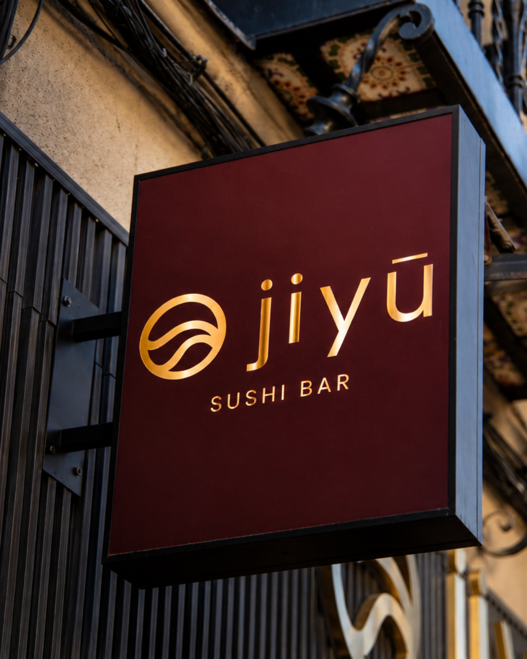 Cartel con logo dorado de Jiyu Sushi Bar Madrid